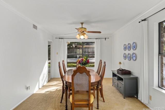 dining area with visible vents, crown molding, and light colored carpet