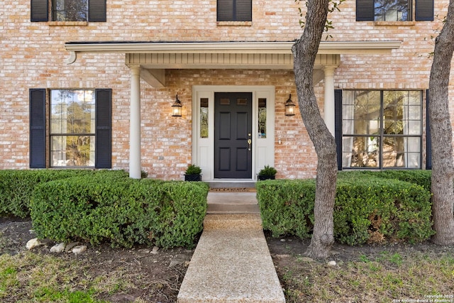 view of exterior entry with brick siding