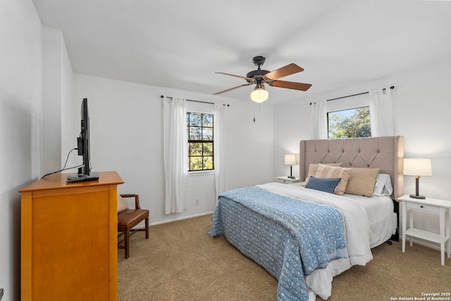 bedroom featuring multiple windows, ceiling fan, and light carpet