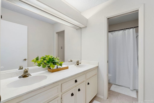 bathroom featuring tile patterned flooring, a sink, toilet, and double vanity