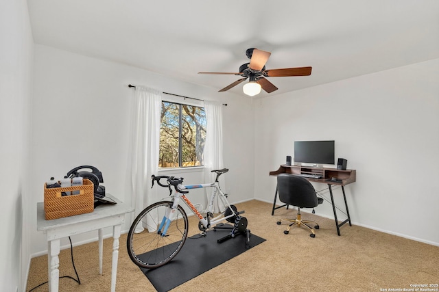 carpeted home office with baseboards and a ceiling fan