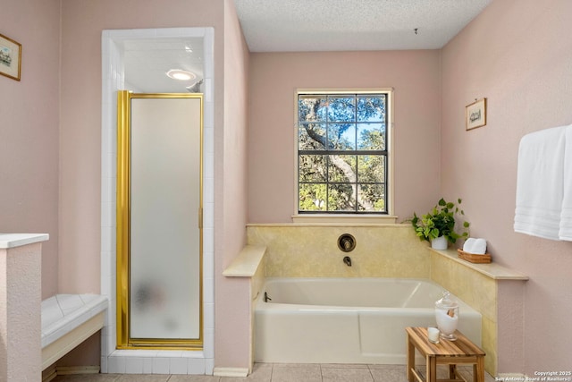 full bathroom featuring tile patterned flooring, a shower stall, a textured ceiling, and a bath