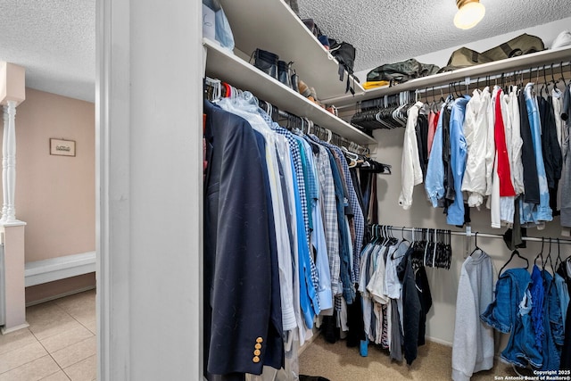 spacious closet with light tile patterned floors and ornate columns