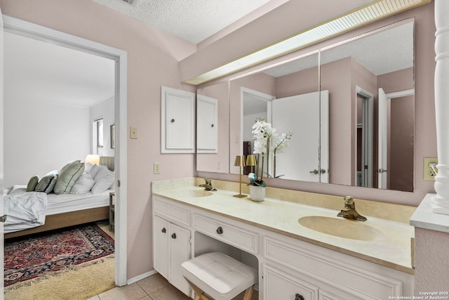 ensuite bathroom featuring double vanity, ensuite bathroom, tile patterned flooring, a textured ceiling, and a sink