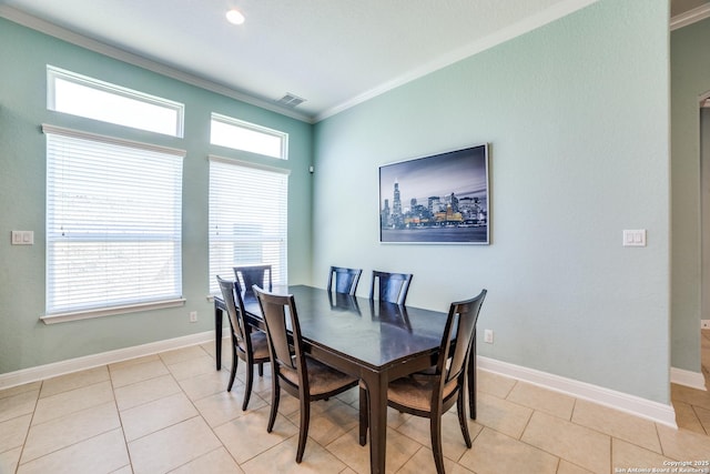 dining area featuring baseboards, light tile patterned flooring, visible vents, and crown molding