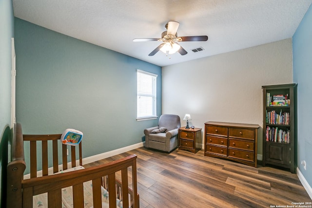 bedroom with ceiling fan, dark wood-style flooring, visible vents, and baseboards