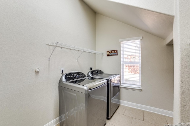 laundry room featuring laundry area, light tile patterned floors, separate washer and dryer, and a wealth of natural light