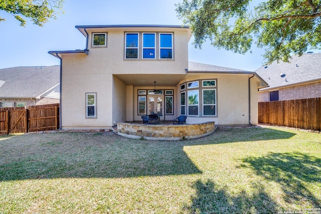 rear view of house featuring a fenced backyard, a yard, a patio, and stucco siding