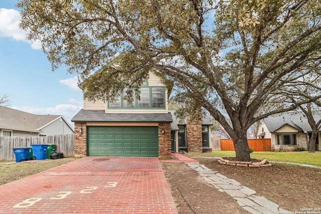 traditional home featuring a garage, fence, decorative driveway, and brick siding