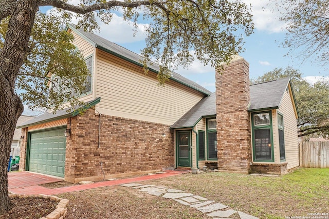 view of front facade with decorative driveway, brick siding, a chimney, fence, and a front lawn