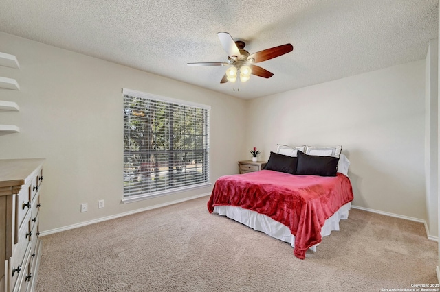 carpeted bedroom with ceiling fan, baseboards, and a textured ceiling