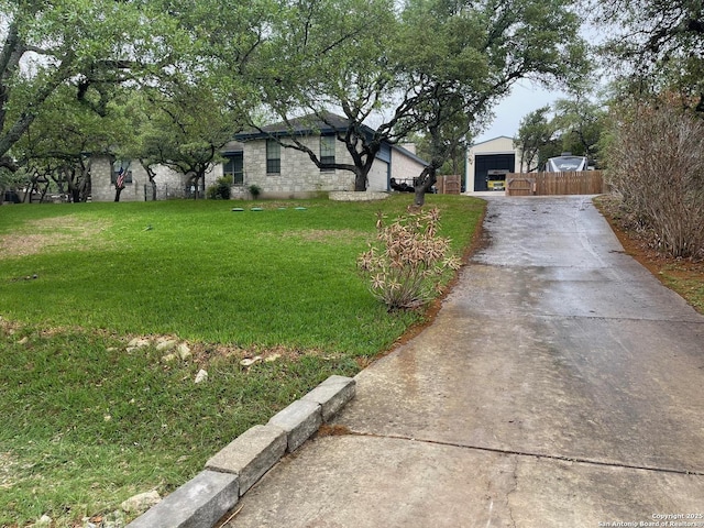 view of yard featuring fence and concrete driveway