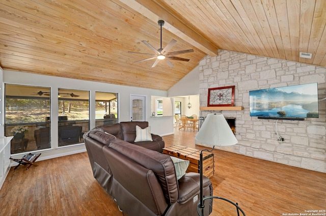 living room featuring wood ceiling, a stone fireplace, wood finished floors, and beamed ceiling