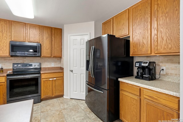 kitchen featuring light tile patterned floors, stainless steel appliances, tasteful backsplash, and light countertops