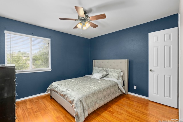 bedroom with ceiling fan, baseboards, and wood finished floors