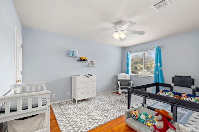 bedroom featuring light wood-style floors, visible vents, ceiling fan, and baseboards