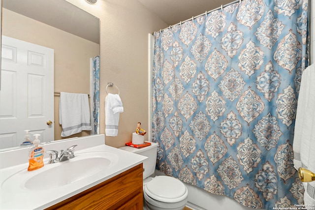 full bathroom featuring curtained shower, vanity, and toilet