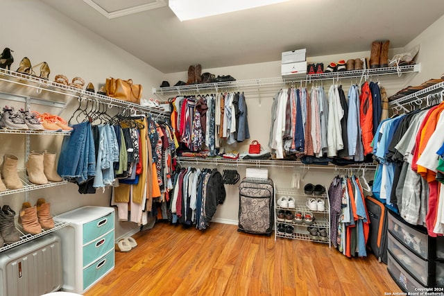 spacious closet with attic access and wood finished floors