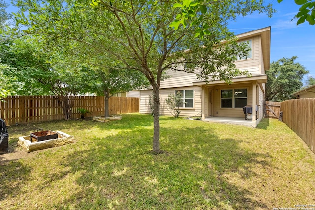 rear view of property with a patio area, a fenced backyard, and a yard