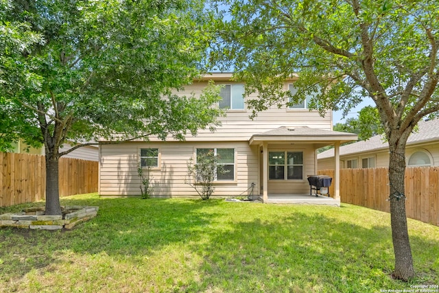 back of property featuring a lawn, a patio area, and a fenced backyard