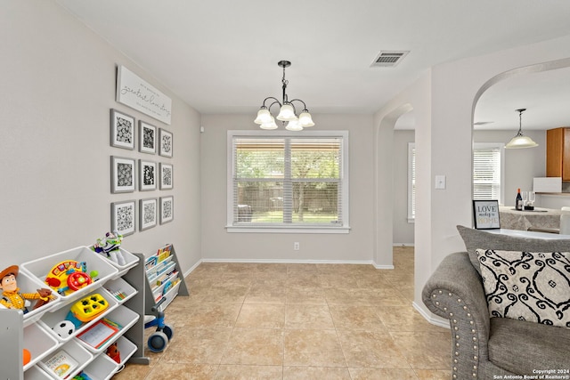 playroom with an inviting chandelier, visible vents, arched walkways, and baseboards