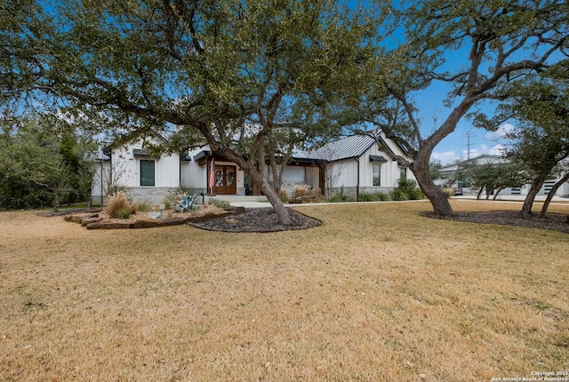 view of front of home with metal roof, a front lawn, and a standing seam roof