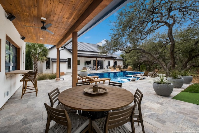 view of patio / terrace featuring ceiling fan, outdoor dining space, and an outdoor pool