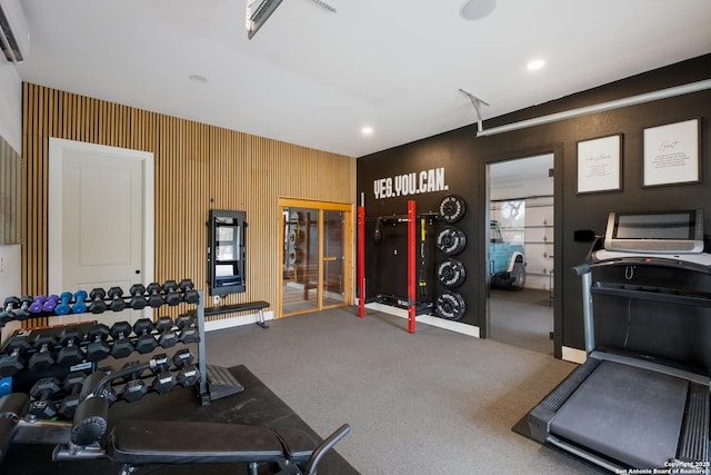 workout area featuring an AC wall unit and carpet flooring