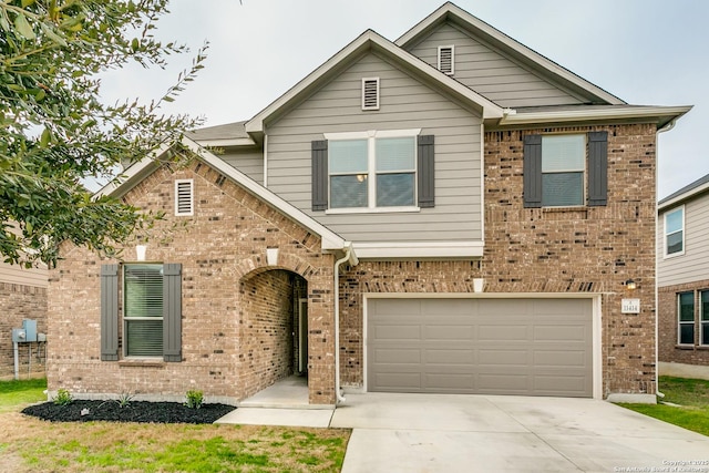 view of front of home featuring driveway, a garage, and brick siding