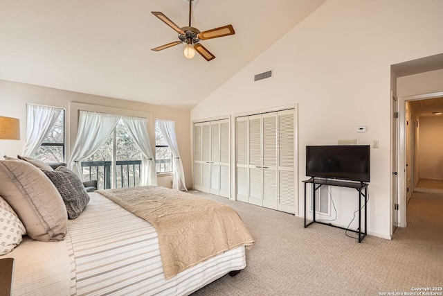 carpeted bedroom with visible vents, ceiling fan, access to exterior, high vaulted ceiling, and two closets