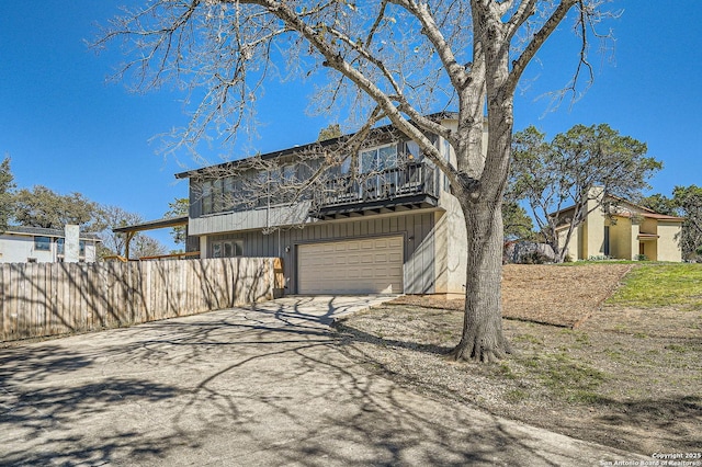 exterior space featuring an attached garage, fence, and concrete driveway