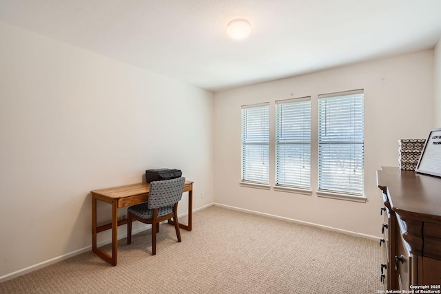 office space featuring light carpet and baseboards