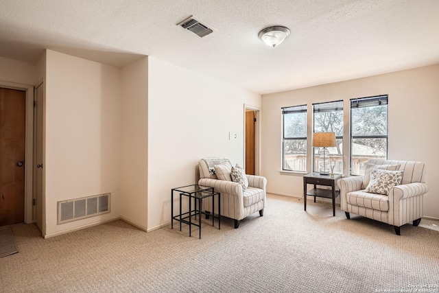 living area featuring a textured ceiling, carpet, and visible vents