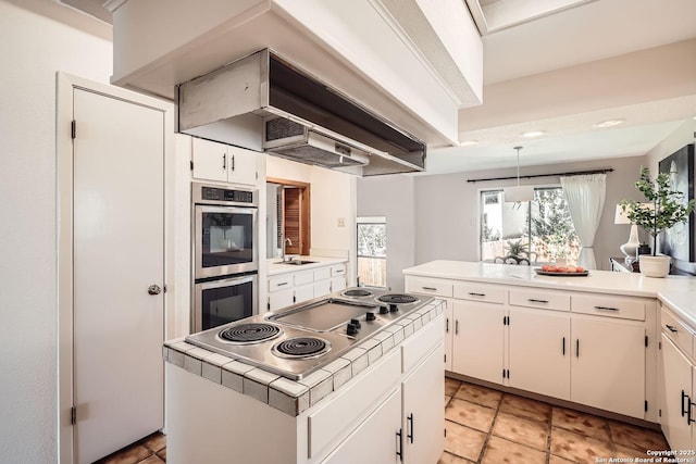 kitchen with appliances with stainless steel finishes, white cabinets, a sink, and light countertops