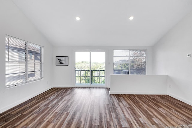 spare room with vaulted ceiling, dark wood finished floors, and baseboards