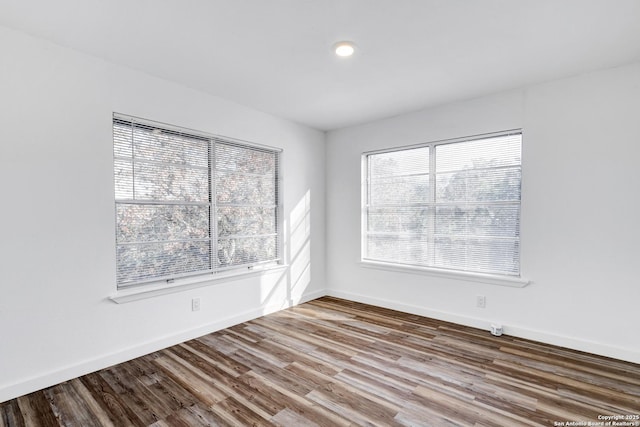 empty room with wood finished floors and baseboards