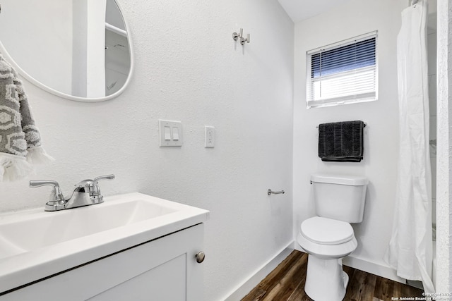 bathroom with baseboards, vanity, toilet, and wood finished floors