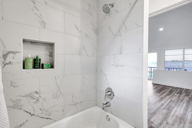 full bath featuring washtub / shower combination and wood finished floors