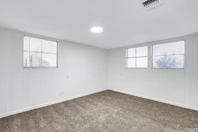 empty room featuring carpet floors, baseboards, and visible vents