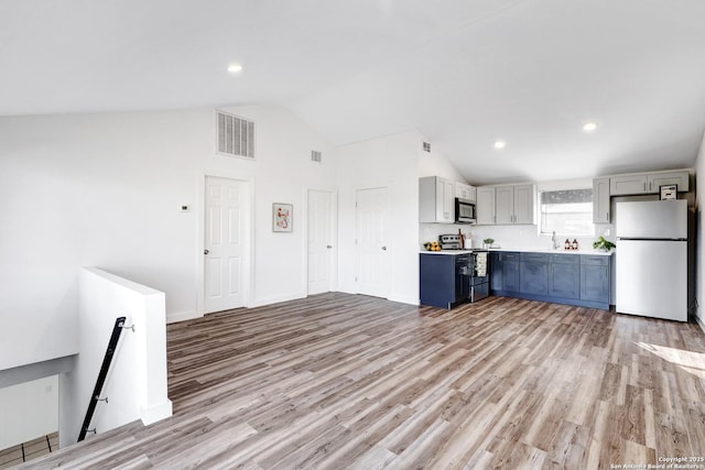 kitchen featuring light wood-style flooring, gray cabinetry, stainless steel appliances, visible vents, and light countertops