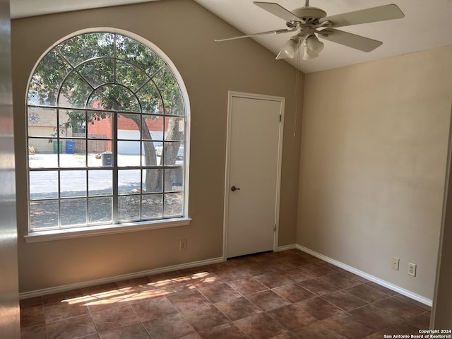 spare room featuring a ceiling fan, lofted ceiling, and baseboards