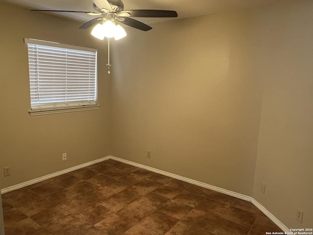 spare room featuring baseboards and a ceiling fan