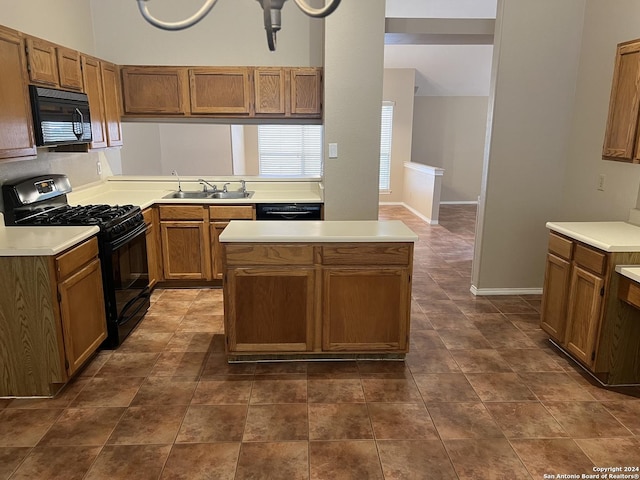 kitchen featuring black appliances, light countertops, and a sink