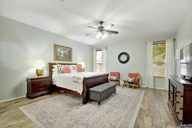 bedroom with light wood-style floors, multiple windows, and baseboards