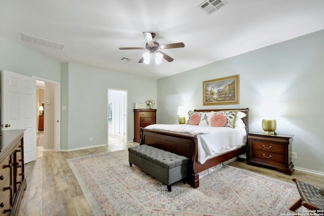 bedroom with light wood-style flooring, visible vents, and baseboards