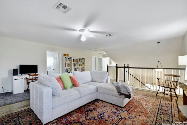 living area featuring ceiling fan, visible vents, and wood finished floors