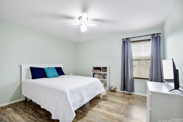 bedroom featuring ceiling fan, baseboards, and wood finished floors