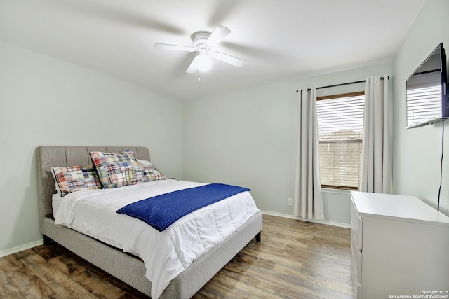 bedroom with ceiling fan, baseboards, and dark wood finished floors