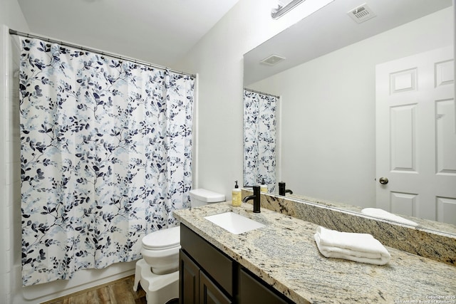 bathroom with toilet, wood finished floors, vanity, visible vents, and shower / tub combo with curtain