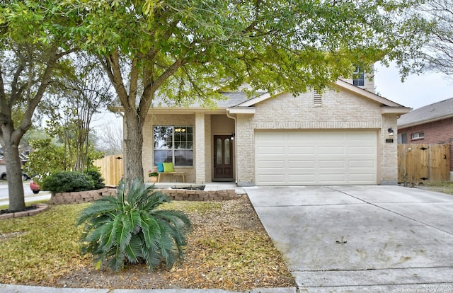 view of front facade featuring a garage, driveway, fence, and brick siding